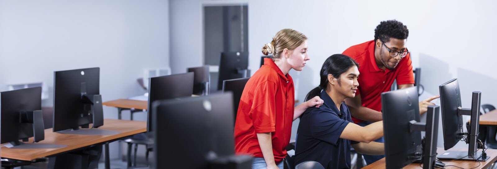 A group of men and women looking at a computer monitor