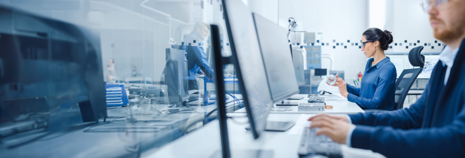 Close up of a man and a woman working on computer workstations